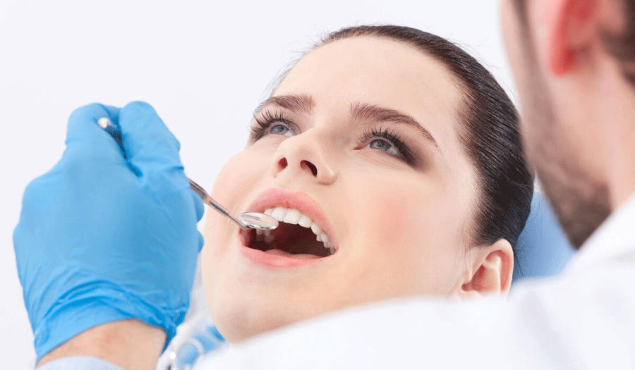 Professionelle Zahnreinigung - Frau bei der Zahnkontrolle mit Zahnarzt